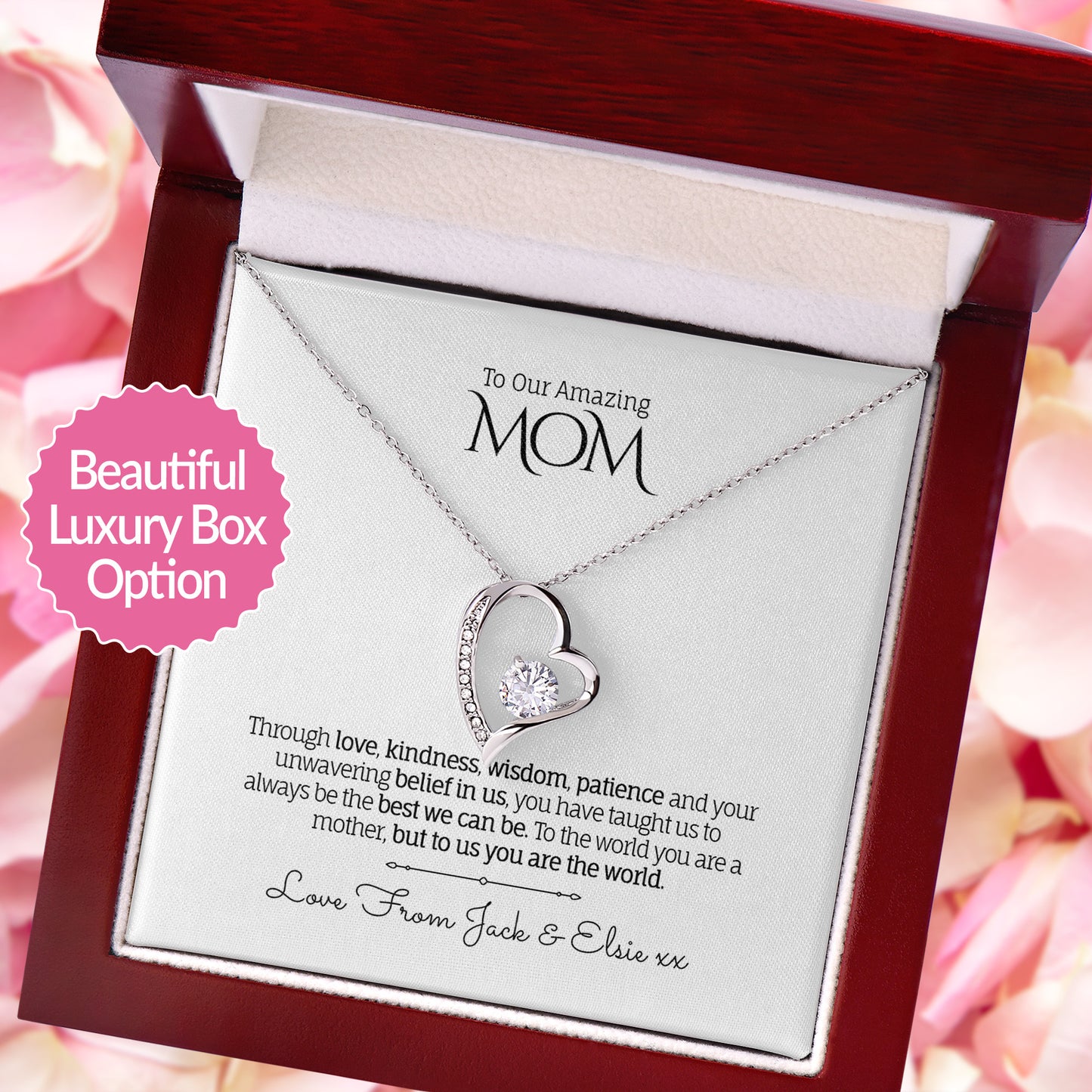 Heart-shaped necklace in a decorative box with a message for 'Mom' on a pink floral background.