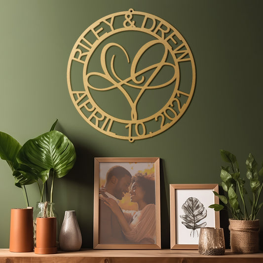 Infinite Love Personalized Metal Decor in Gold customized with names and date on a green wall, below which are framed photos and plants.