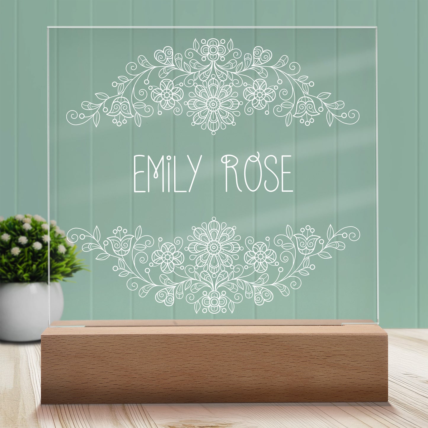Vintage Floral Personalized Night Light with Battery powered base featured on a light timber table with a mint green panelled wall and lush green pot plant with white flowers in the background.
