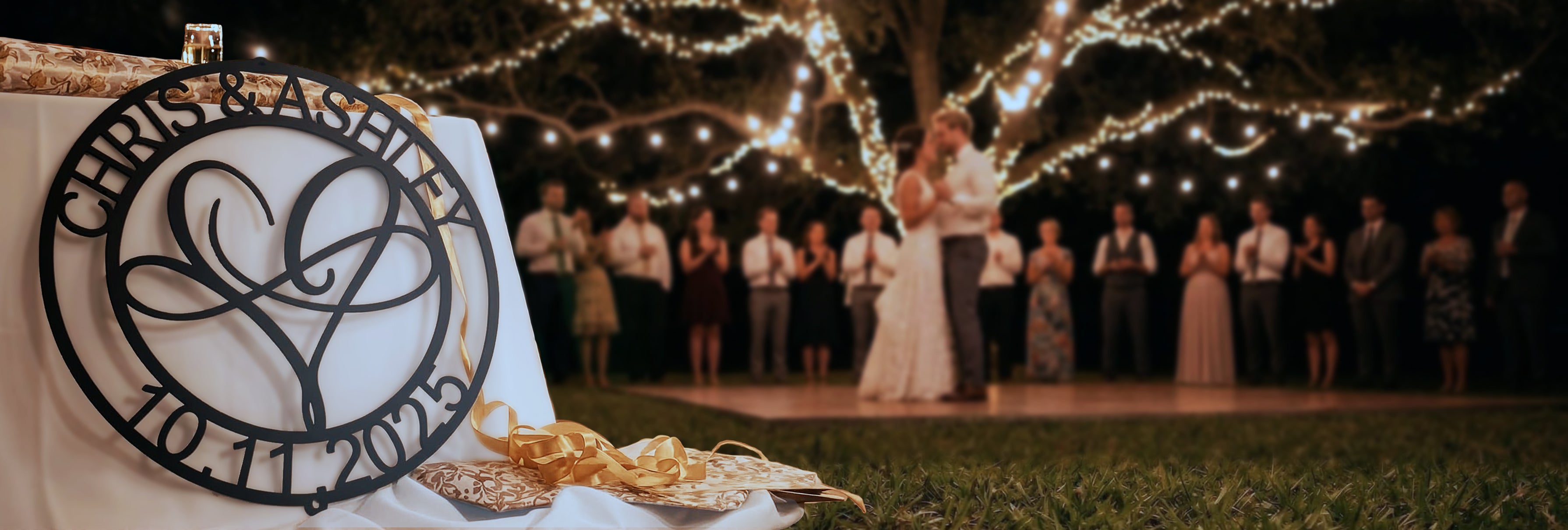 Wedding ceremony with guests and a decorative sign in the foreground.