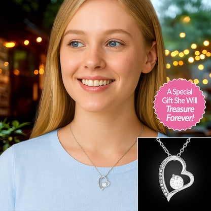 Young girl wearing 14k White Gold Finish Forever Love necklace, against a bokeh night lights background.
