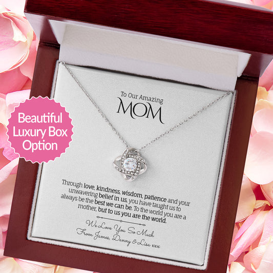 Necklace with a sentimental message card in a decorative box, surrounded by pink flowers.