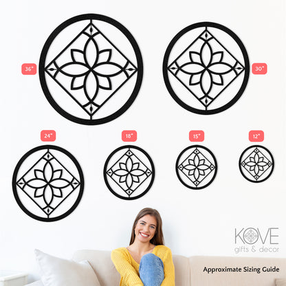 A women sits on a couch with sample metal decor pieces on the wall behind her showing the various sizes available.