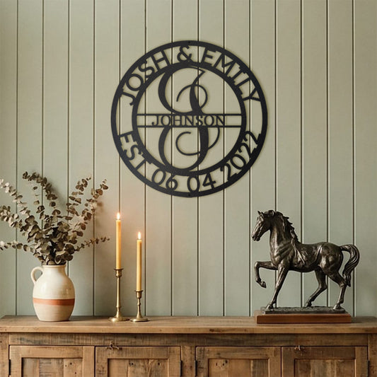 BLACK Elaborate Name Monogram Personalized Metal Decor mounted on a sage green panelled wall above a wooden sideboard.