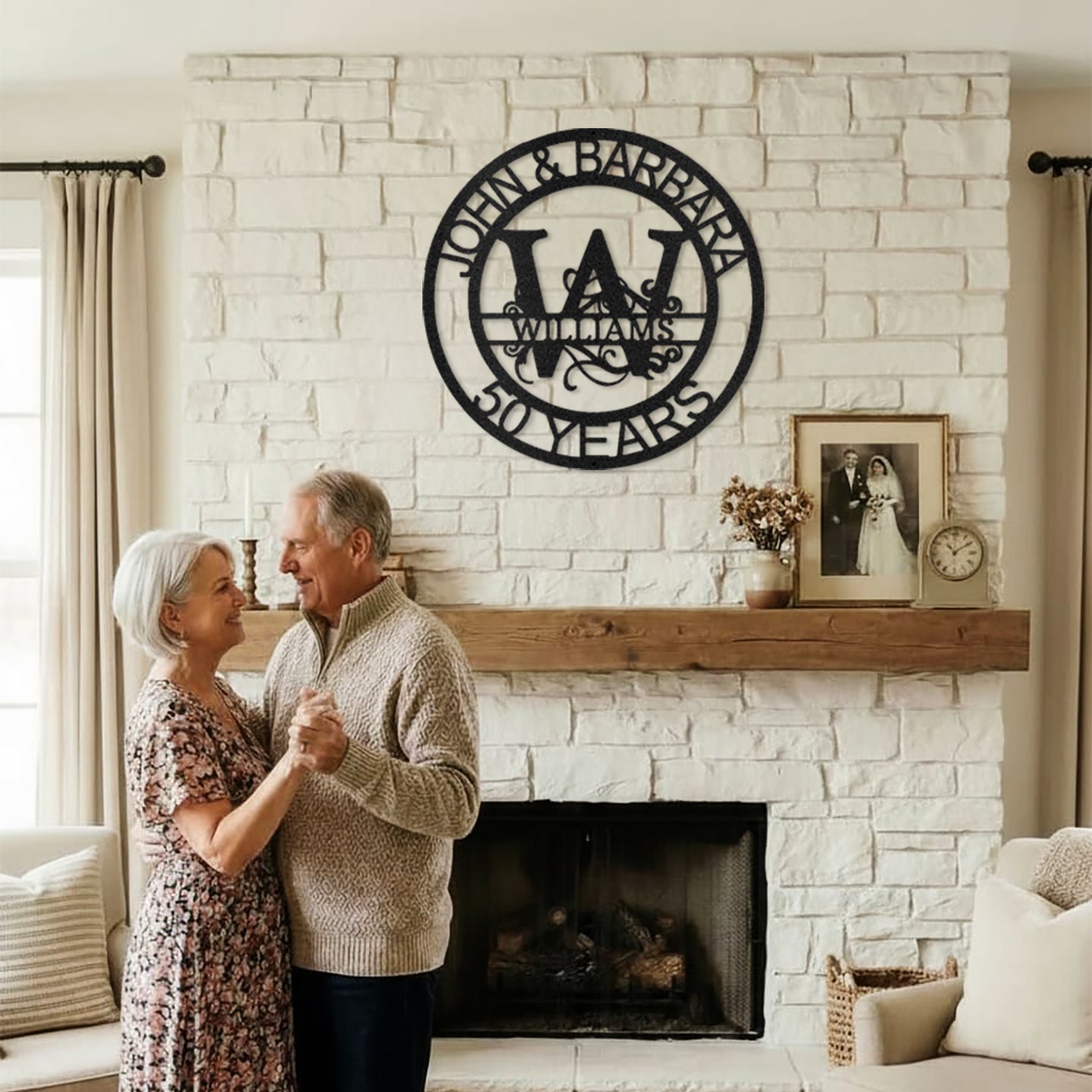 Couple dancing in a cozy living room with Black Fanciful Monogram Personalized Metal Decor mounted above the fireplace.