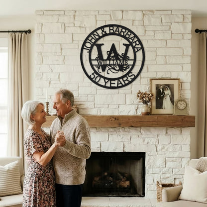 Couple dancing in a cozy living room with Black Fanciful Monogram Personalized Metal Decor mounted above the fireplace.