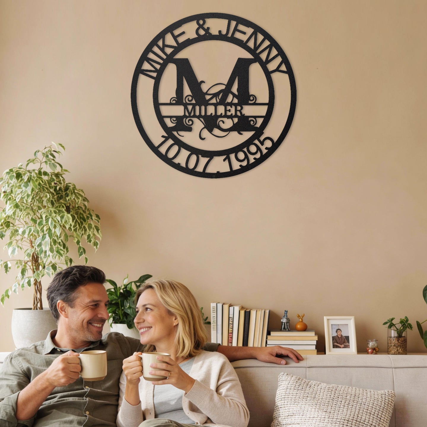 Couple sitting on a couch enjoying coffee with a Black Fanciful Monogram Personalized Metal Decor piece on the wall above them.