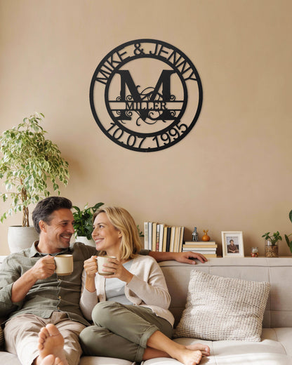 Couple sitting on a couch enjoying coffee with a Black Fanciful Monogram Personalized Metal Decor piece on the wall above them.
