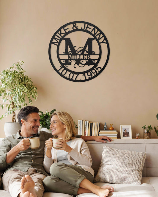 Couple sitting on a couch enjoying coffee with a Black Fanciful Monogram Personalized Metal Decor piece on the wall above them.