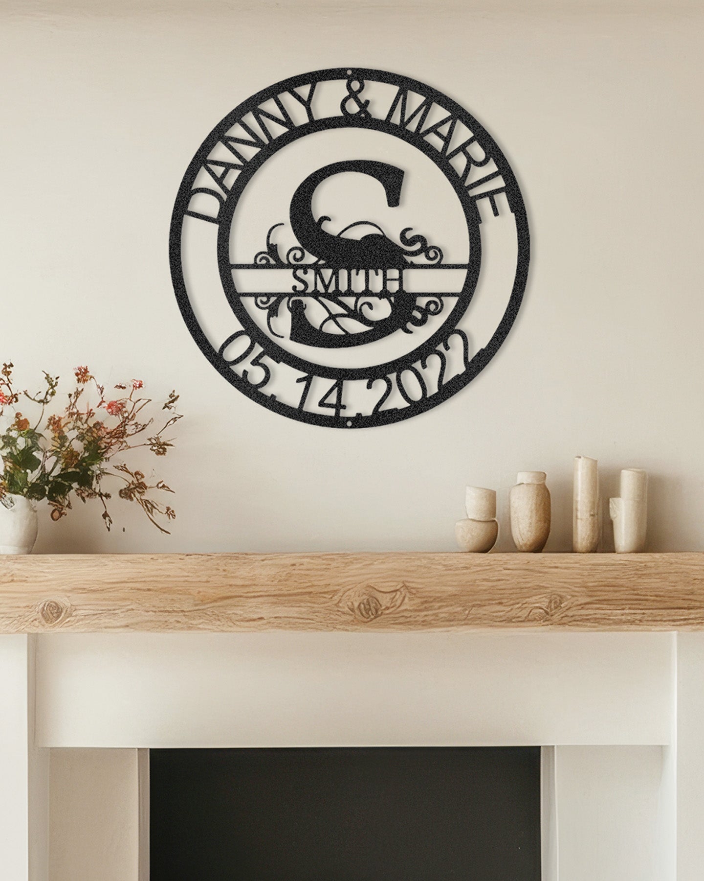 Black Fanciful Monogram Personalized Metal Decor mounted above a modern fireplace.