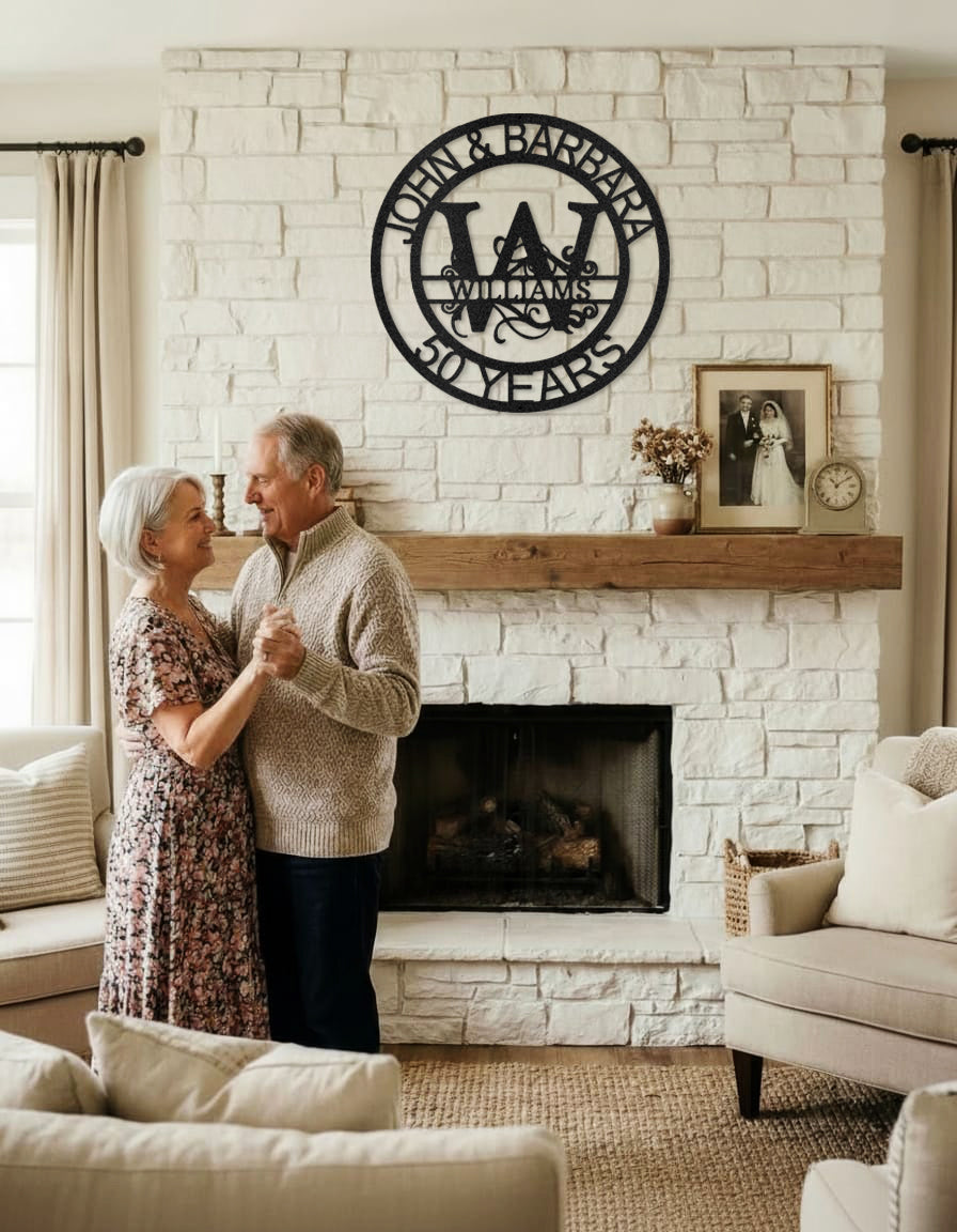 Couple dancing in a cozy living room with Black Fanciful Monogram Personalized Metal Decor mounted above the fireplace.