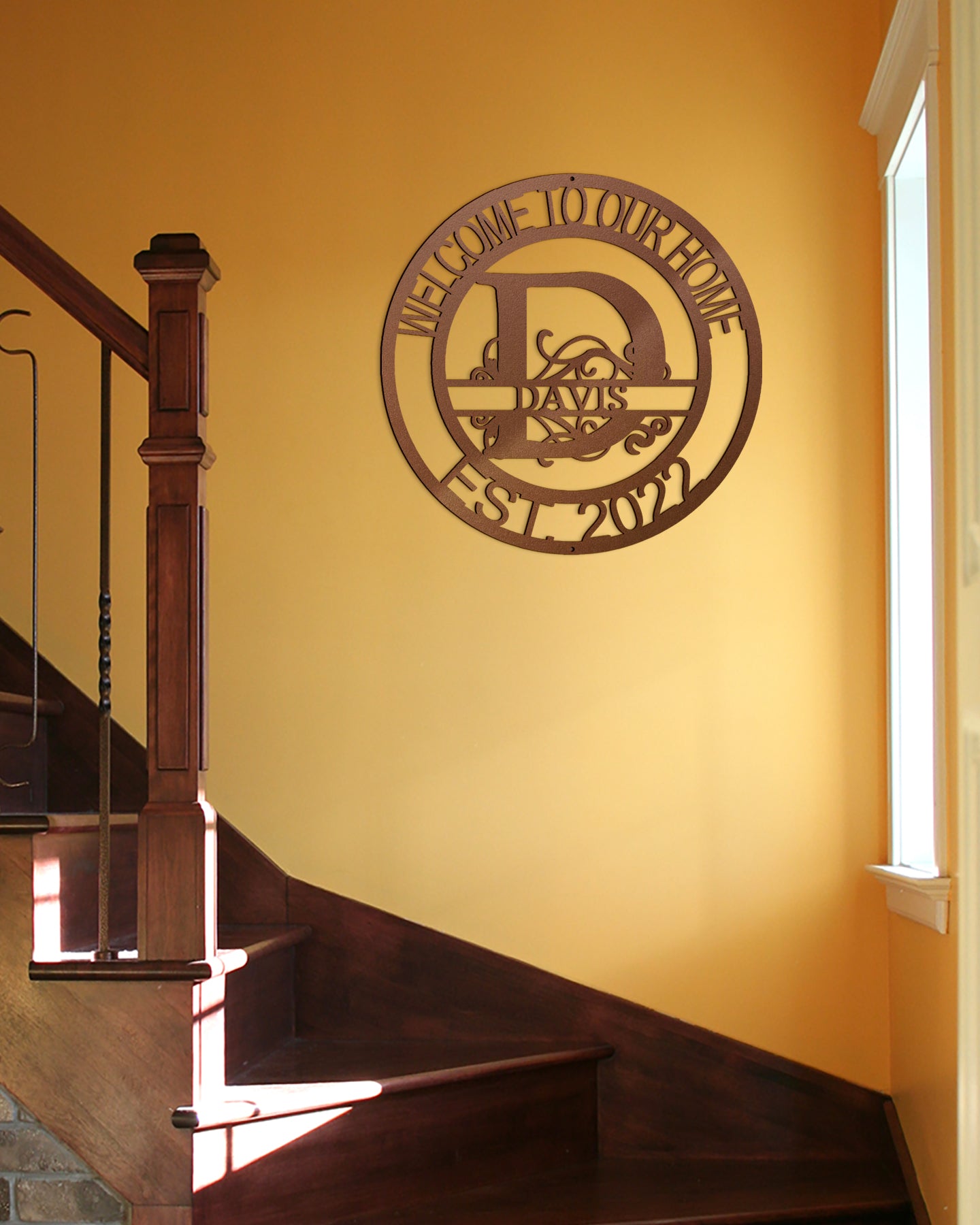 Copper Fanciful Monogram Personalized Metal Decor featured on a bright yellow wall over a staircase in a traditional home.