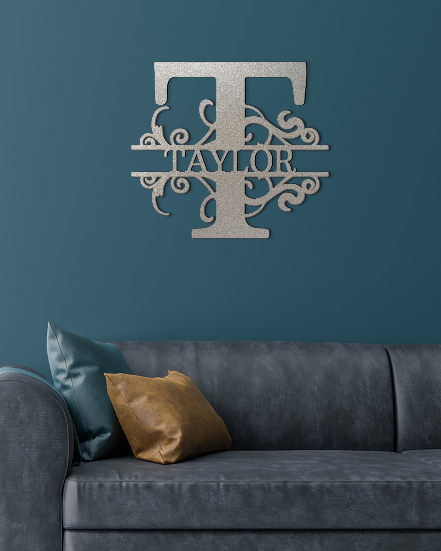 Silver Split Letter Monogram Personalized Metal Decor featured on a deep teal wall above a gray leather couch in a modern living room.