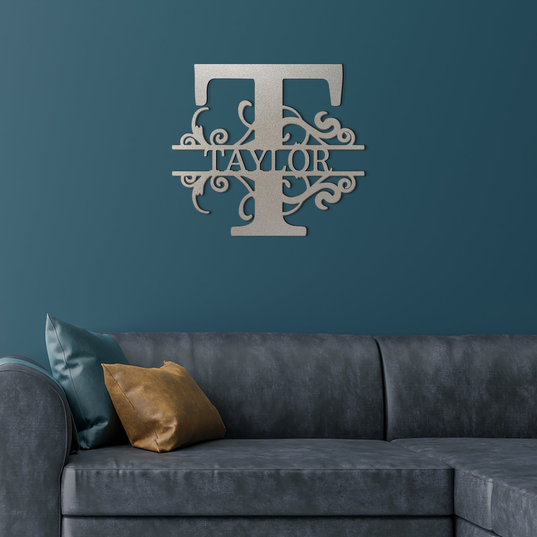 Silver Split Letter Monogram Personalized Metal Decor featured on a deep teal wall above a gray leather couch in a modern living room.