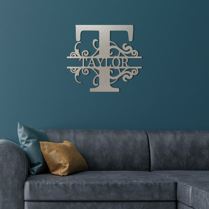 Silver Split Letter Monogram Personalized Metal Decor featured on a deep teal wall above a gray leather couch in a modern living room.