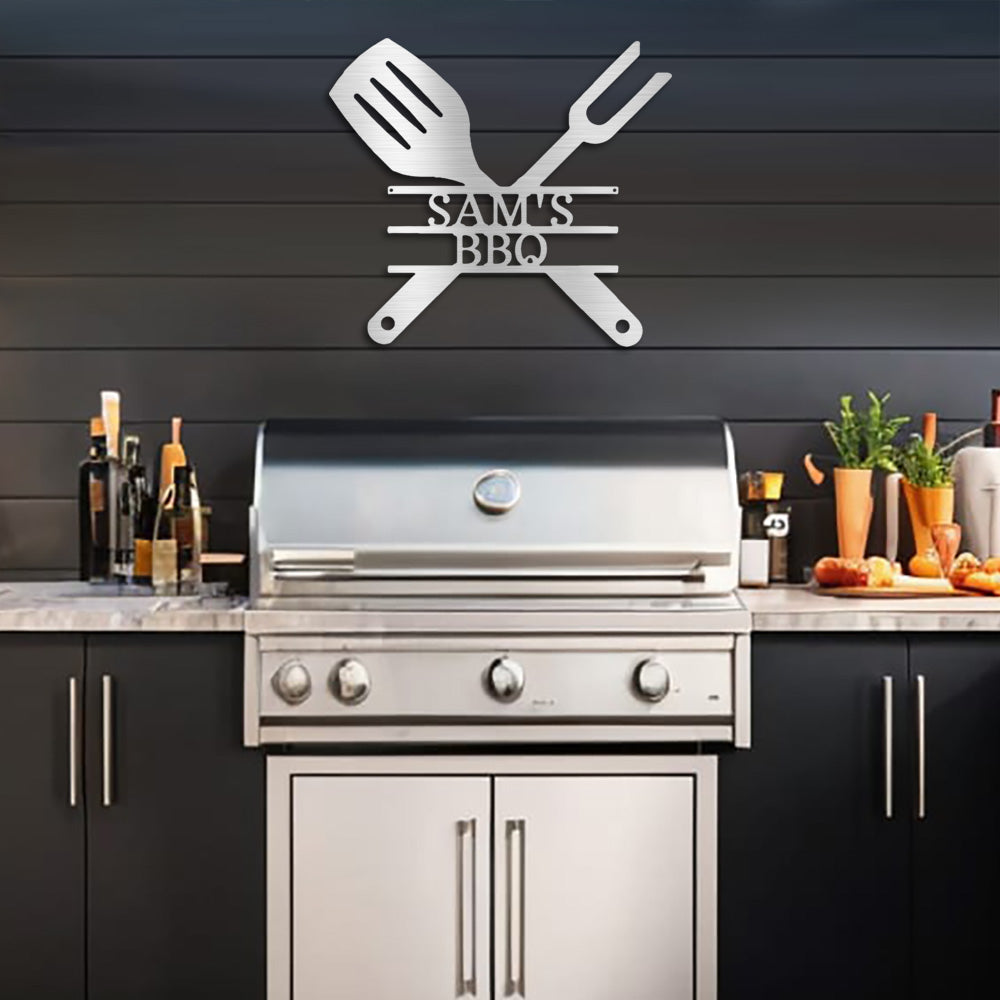 Silver BBQ Grill Utensils Personalized Metal Decor featured on a black timber wall in a modern outdoor kitchen above a sleek stainless steel barbeque