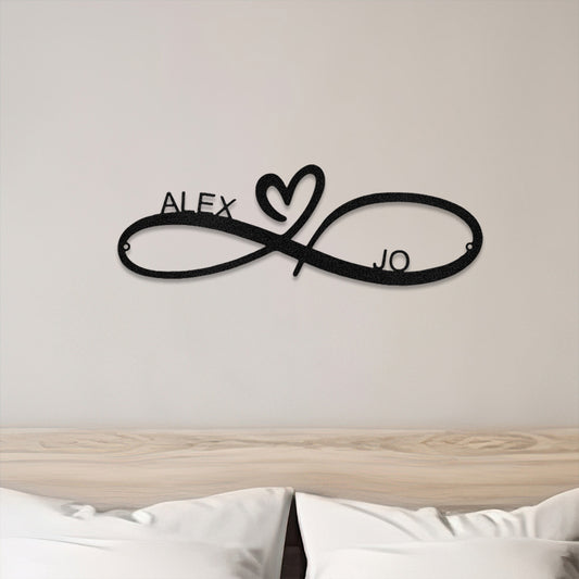 Black Infinity Heart Couple Personalized Metal Decor featured above a bed on a neutral bedroom wall