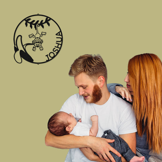 Black Our Little Monkey Personalized Metal Decor featured on an olive green wall next to a couple adoring their beautiful baby