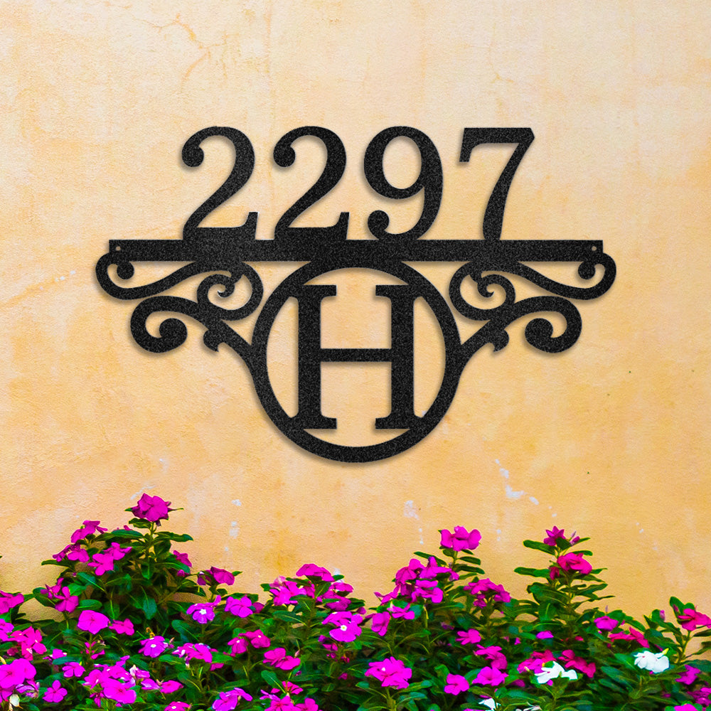 Sophisticated Monogram Number Metal Address Sign in Black, mounted on yellow concrete wall above purple flowers.